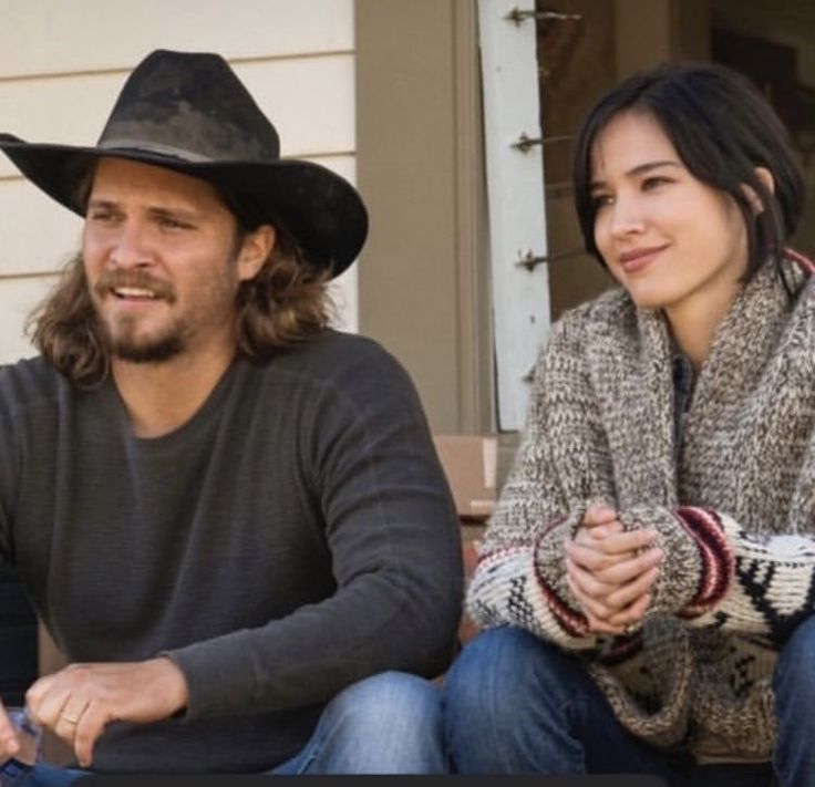 a man and woman sitting next to each other in front of a house with the caption's name on it