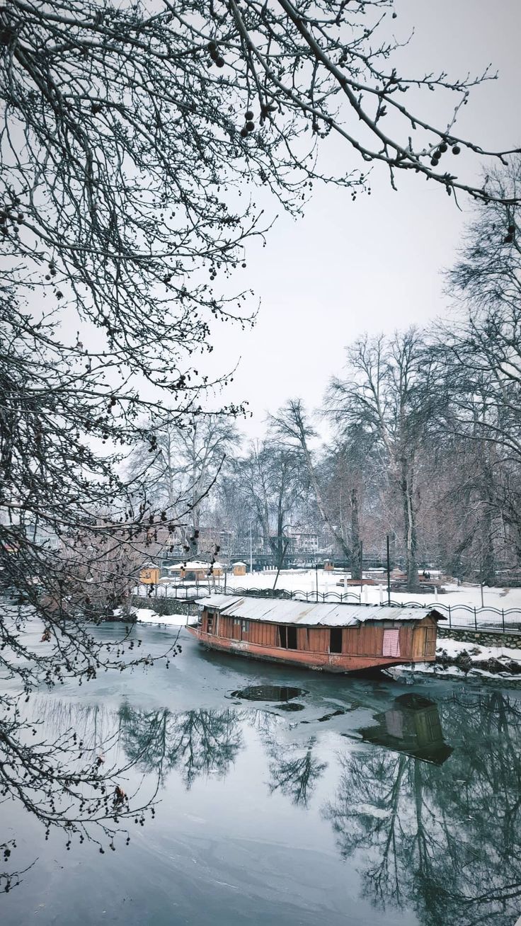 a boat floating on top of a river covered in snow