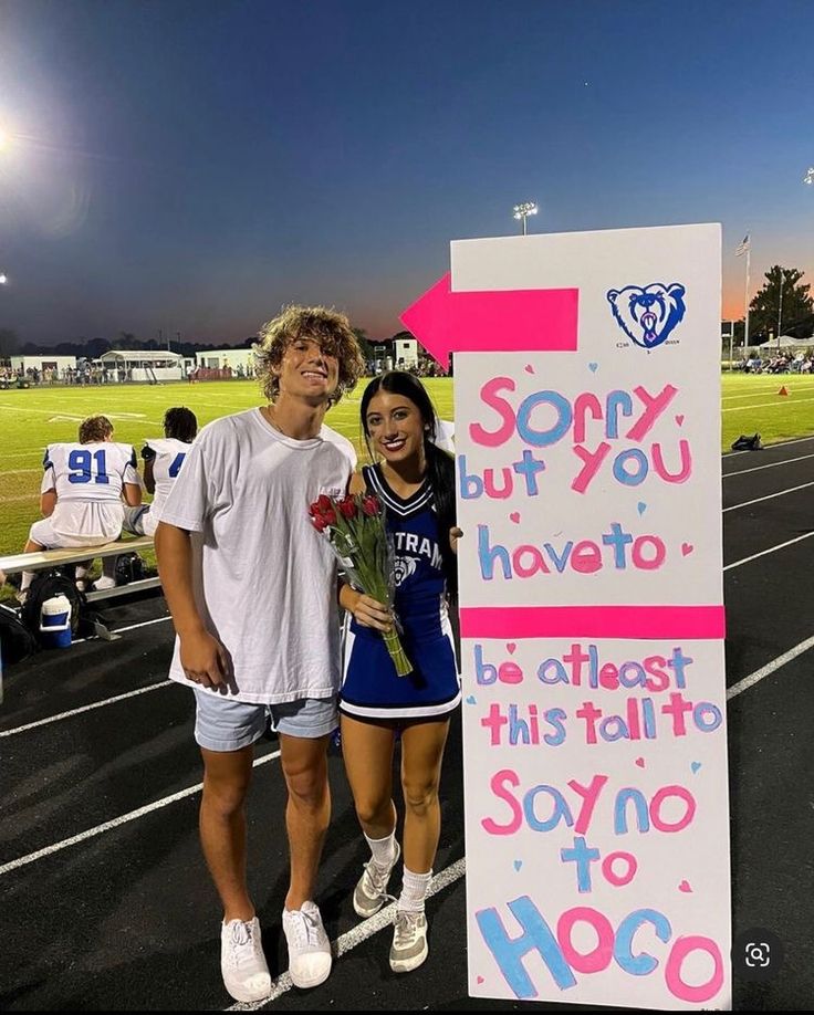 two people standing next to a sign that says sorry but you have to