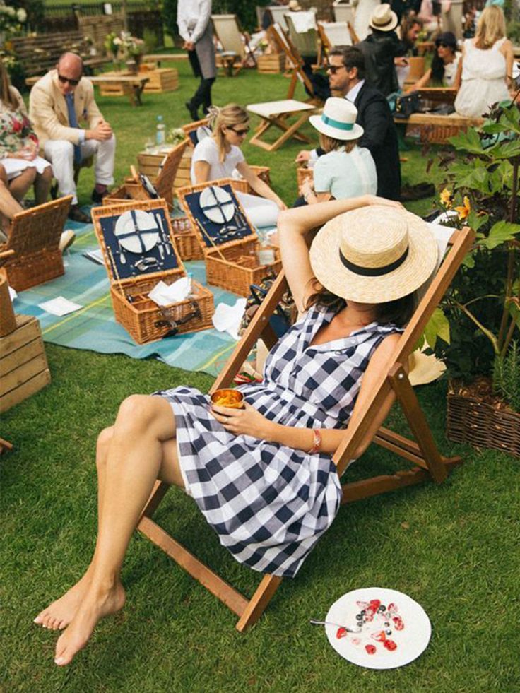 a woman sitting in a chair on top of a lush green field next to other people