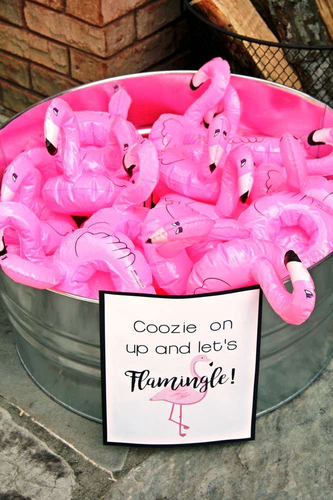 pink flamingos are in a bucket with a sign