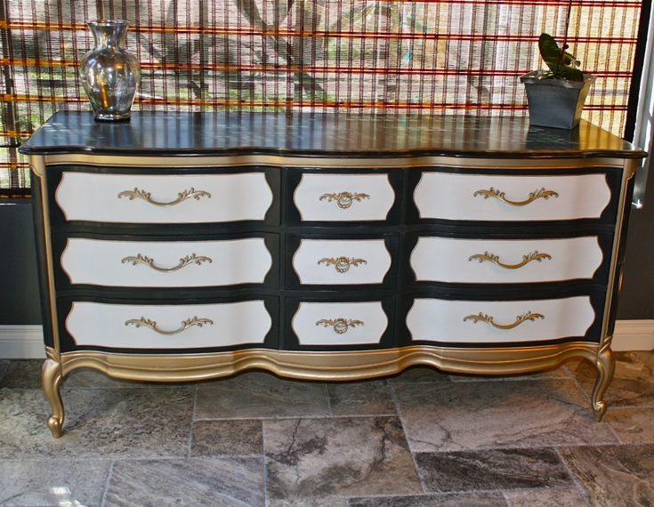 a black and white dresser with gold trim