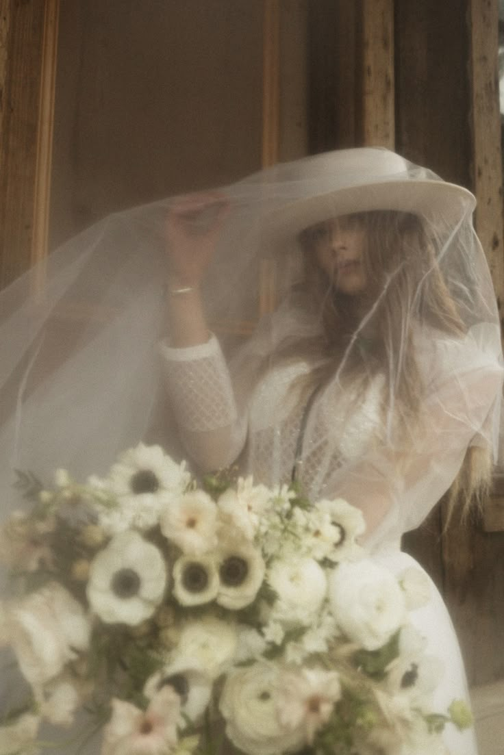 a woman wearing a veil and holding a bouquet