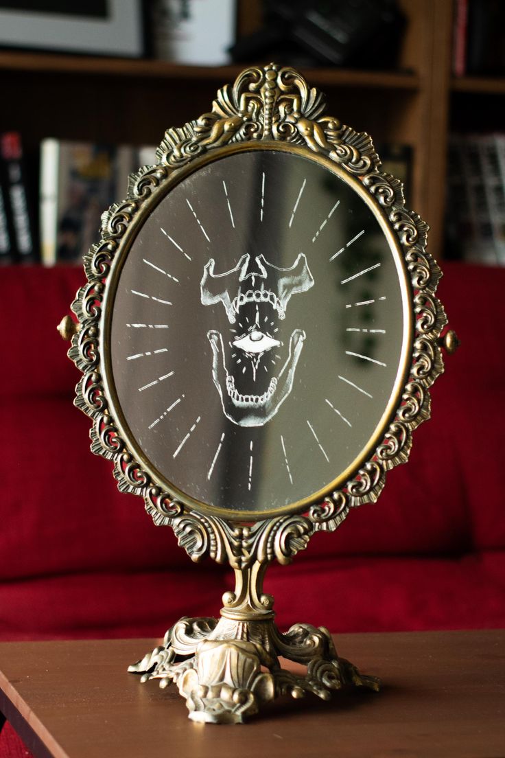 a clock with a face on it sitting on a table in front of a red couch