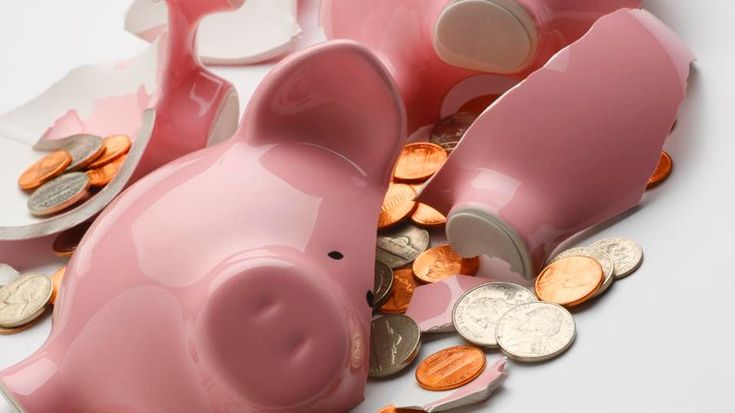 pink piggy bank with coins spilling out of it