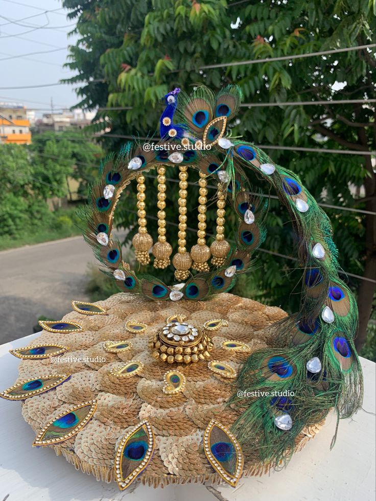 an elaborate peacock headdress with beads and feathers on display in front of trees