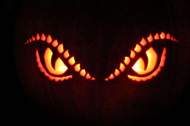 a pumpkin with an evil face carved into it's eyes and glowing in the dark