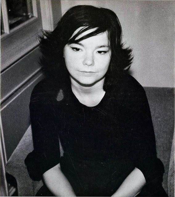 a black and white photo of a woman sitting on the floor