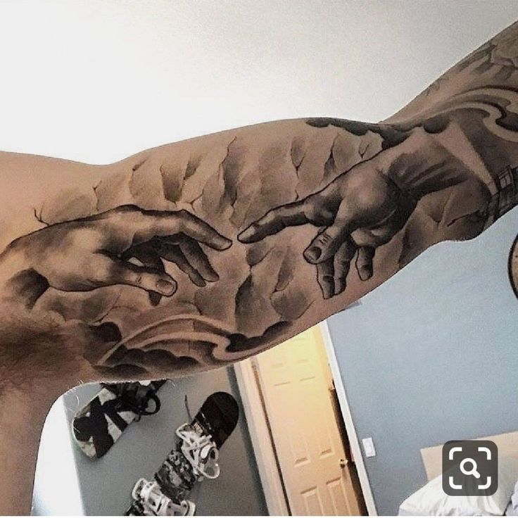 a man with a tattoo on his arm that has the creation of jesus's hands