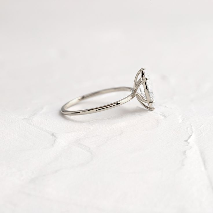 a diamond ring sitting on top of a white surface