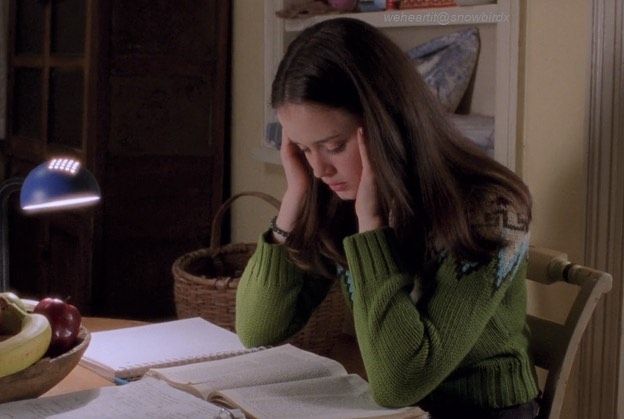 a woman sitting at a table in front of an open book with fruit on it