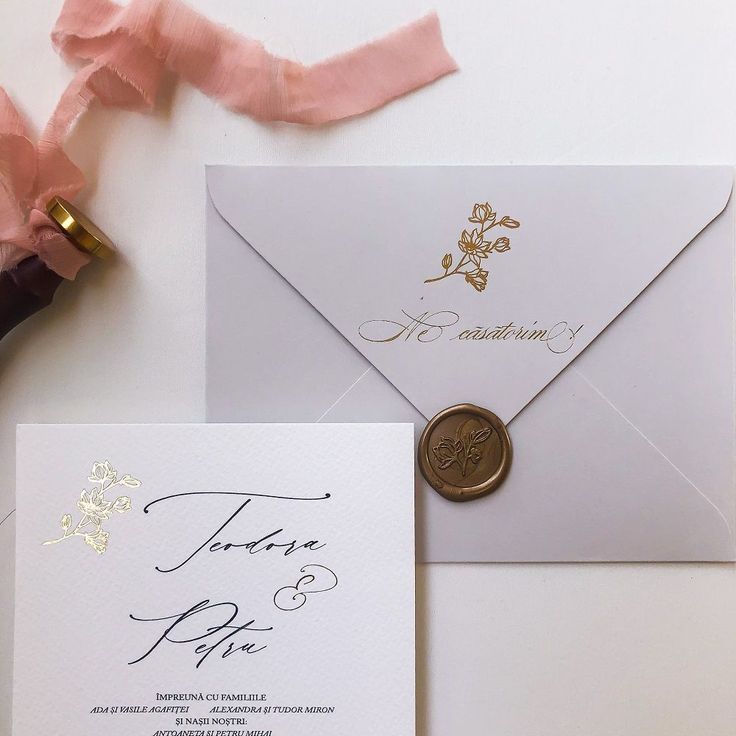 the wedding stationery is laid out on top of an envelope with a wax stamp