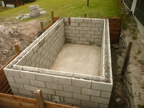 an unfinished concrete pit in the middle of a yard