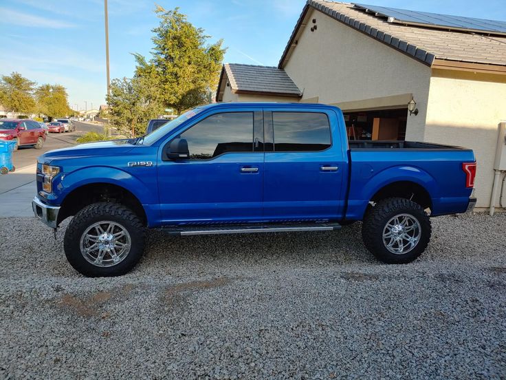 a blue truck parked in front of a house