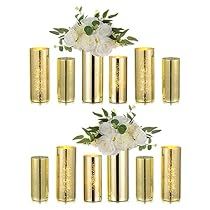 gold vases with white flowers and greenery are arranged in the shape of a pyramid