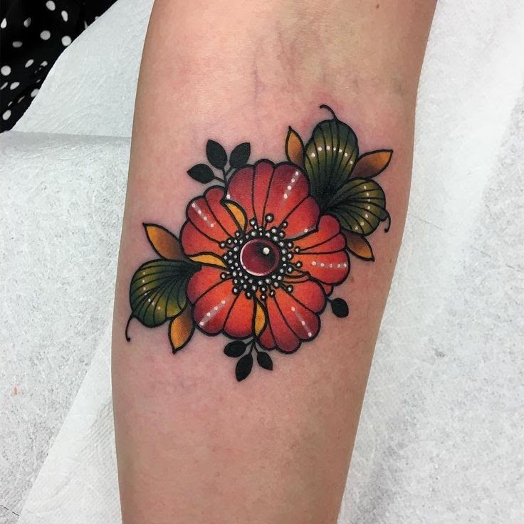 a woman's leg with a flower tattoo on the side of her arm,