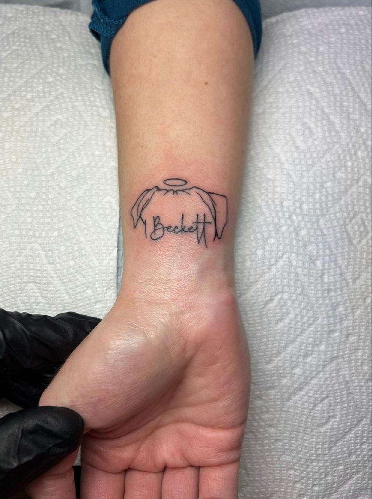 a woman's hand with a small tattoo on the wrist that says, beautiful