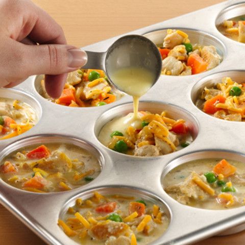 a person pouring sauce into a muffin tin filled with chicken and vegetable casserole