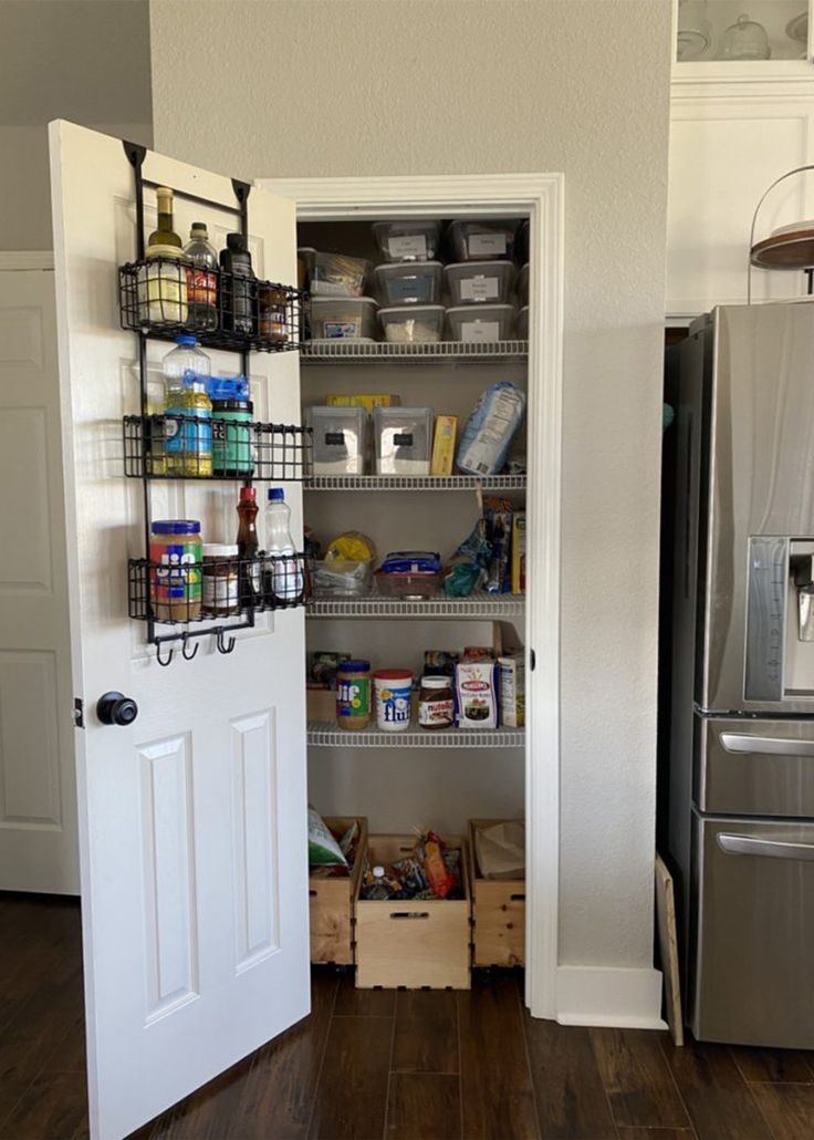 an open pantry door in a kitchen next to a refrigerator