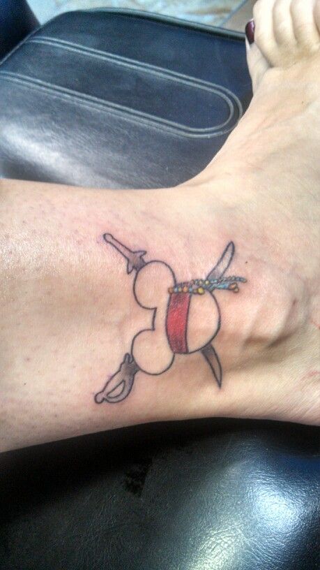 a person with a tattoo on their foot that has a cartoon character holding a knife