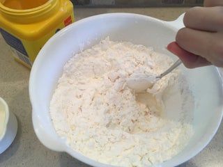 a person mixing ingredients in a white bowl