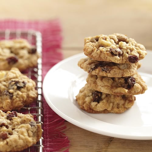 a stack of cookies sitting on top of a white plate next to a cooling rack