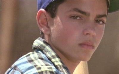 a close up of a person wearing a baseball cap and looking at the camera with a serious look on his face