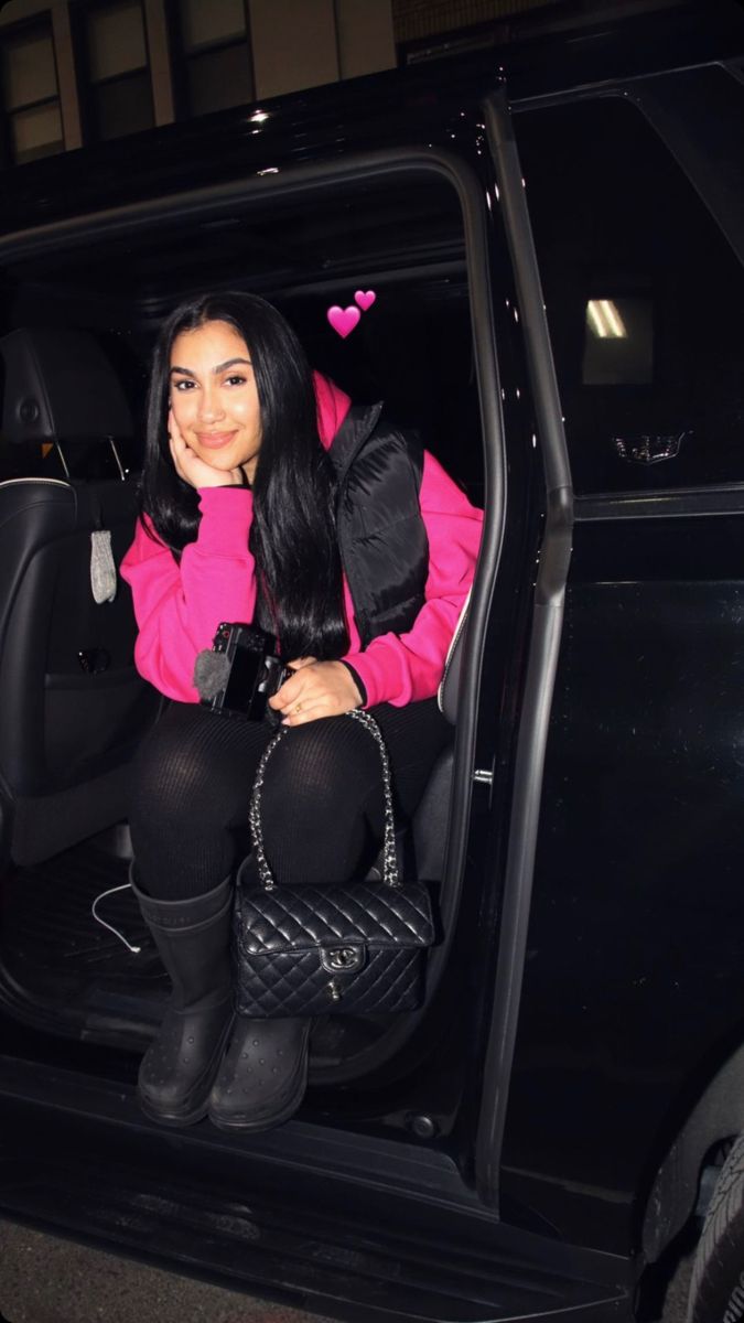 a woman sitting in the back seat of a car with her hand on her hip