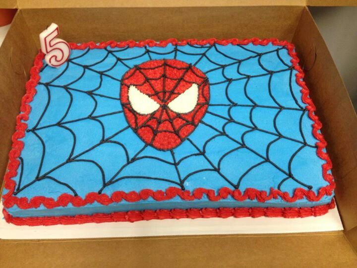 a birthday cake decorated with a spiderman face on top of a cardboard box for someone's 5th birthday