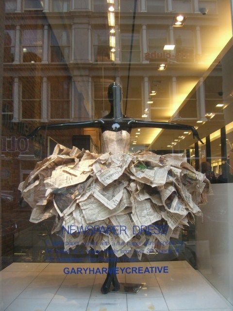 a mannequin made out of newspapers in a window