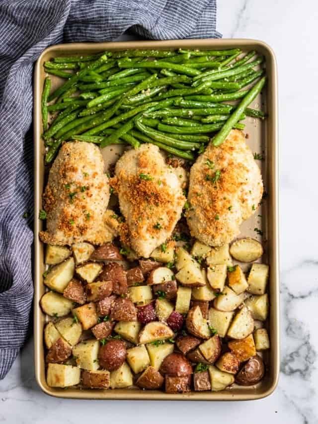 chicken, potatoes and green beans in a casserole dish on a marble surface