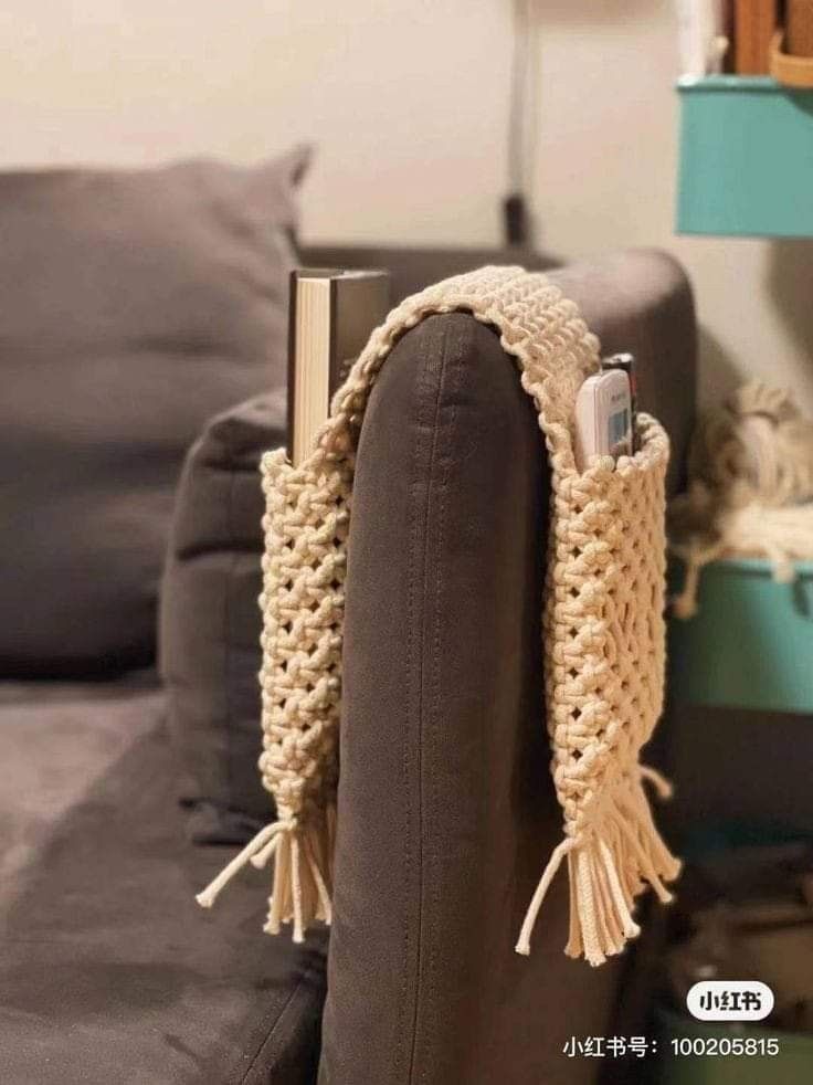 a cell phone is wrapped in a crochet scarf on the back of a couch