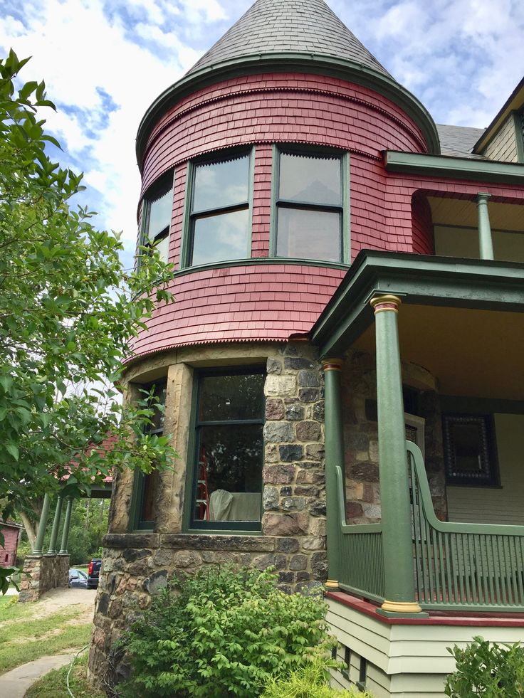 a red and green victorian style house on a sunny day