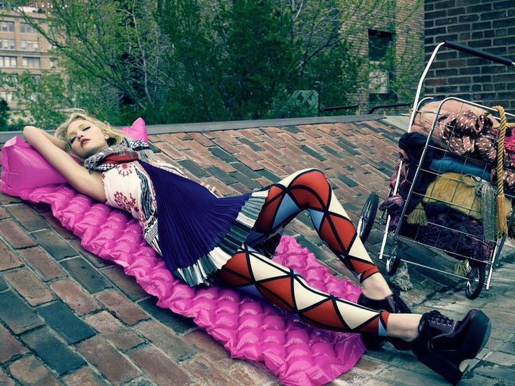 a woman laying on top of a pink blanket