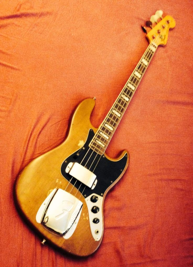 an electric guitar laying on top of a bed