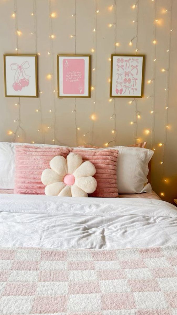 a white bed topped with pillows and blankets next to pictures on the wall above it