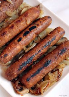 some sausages and onions on a white plate