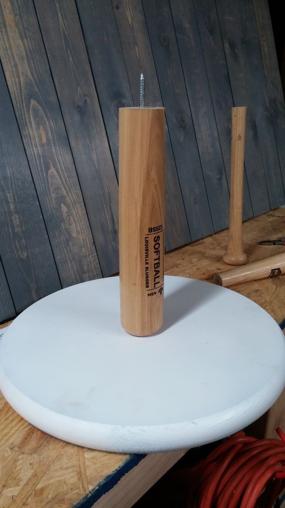 a white surfboard with a wooden stick sticking out of it's end sitting on a table