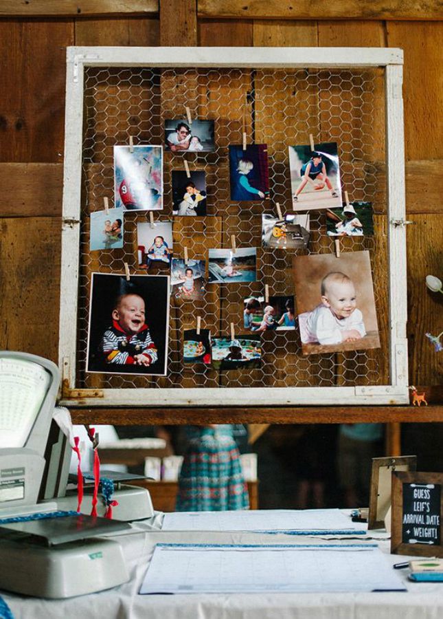 a table topped with pictures and magnets next to a white framed photo on a wooden wall