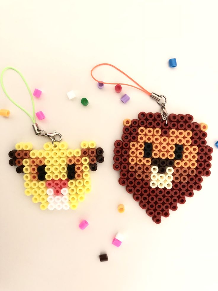 two pieces of bead art on a white surface with beads and confetti