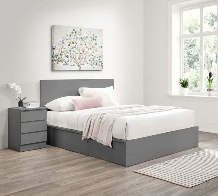 a bedroom with white walls and wooden floors