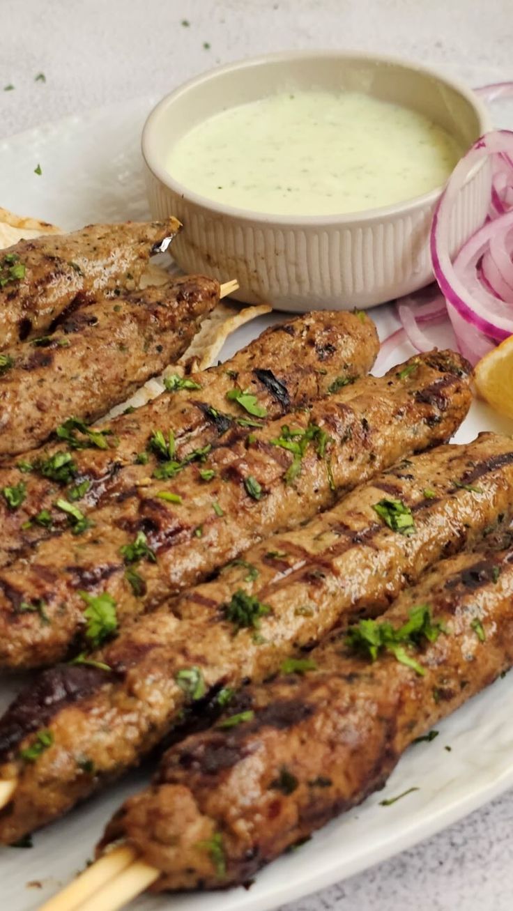 grilled meat and vegetables on a plate with dipping sauce