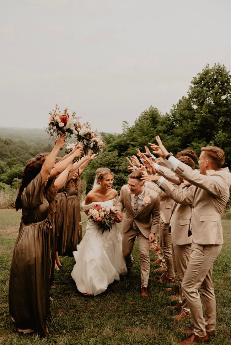 a group of people standing around each other with their hands in the air and holding flowers