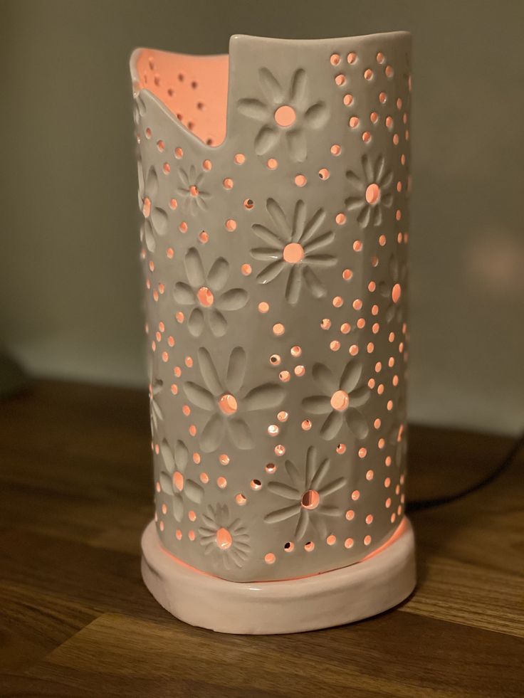 a gray and pink vase sitting on top of a wooden table