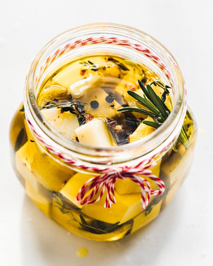 a glass jar filled with pickles and lemons