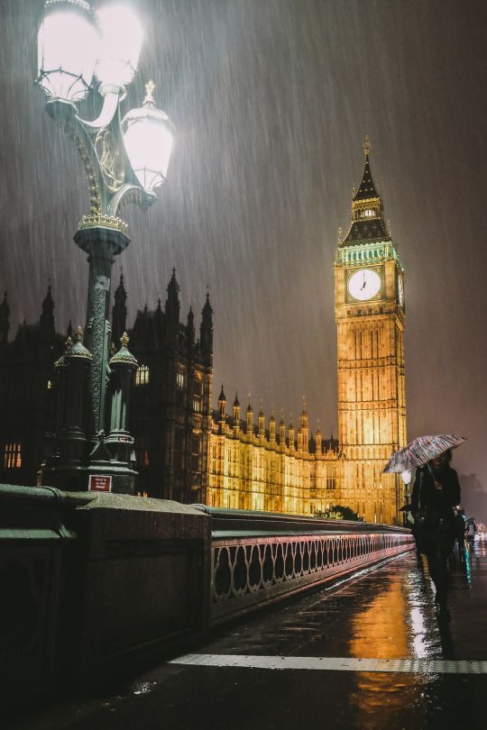 the big ben clock tower towering over the city of london in the rain at night