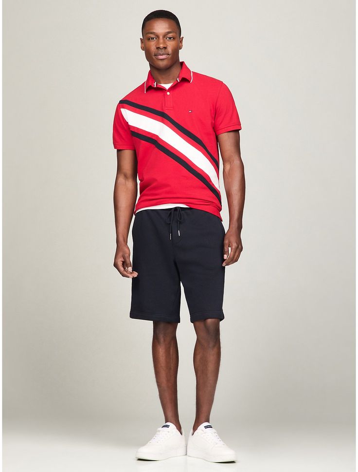 Tommy Hilfiger men's polo. What we do best, the classic polo in stretch pique cotton, cut in an easy fit and featuring our signature stripe banner across the chest.  Material: 97% Regenerative Cotton, 3% Elastane. Sporty Striped Polo Shirt With Signature Stripes, Sporty Collared Polo Shirt With Three Stripes, Golf Polo Shirt With Three Stripes, Casual Three Stripes Polo Shirt For Golf, Tommy Hilfiger Casual Sports Tops, Sporty Striped Collared Polo Shirt, Sporty Striped Cotton Polo Shirt, Casual Golf Polo Shirt With Contrast Stripes, Casual Polo Shirt With Contrast Stripes For Golf