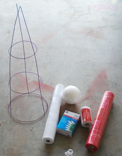 some craft supplies are laying out on the floor next to a wire cone and tube