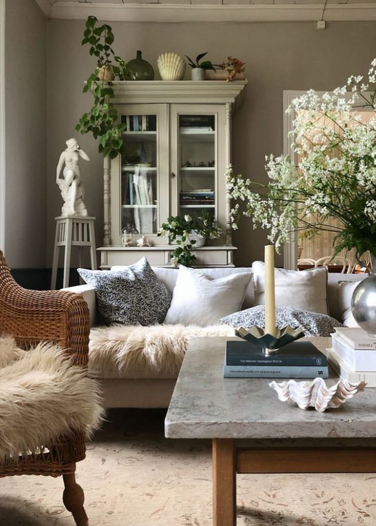 a living room filled with lots of furniture and flowers on top of a coffee table