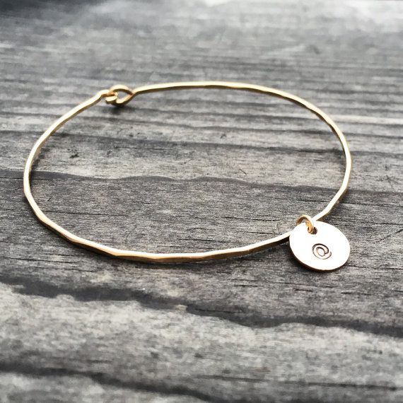 A lovely personalized bangle made from 14k gold fill featuring a small hammered disc Minimalist Hand-stamped Yellow Gold Jewelry, Minimalist Engraved Round Bracelets, Engraved Minimalist Bracelets, Nickel-free Gold Name Bracelet For Everyday, Minimalist Adjustable Jewelry With Engraving Option, Simple Adjustable Hand Stamped Jewelry, Minimalist Stamped Bangle Jewelry, Minimalist Stamped Bracelet Jewelry, Minimalist Hand Stamped Round Disc Jewelry